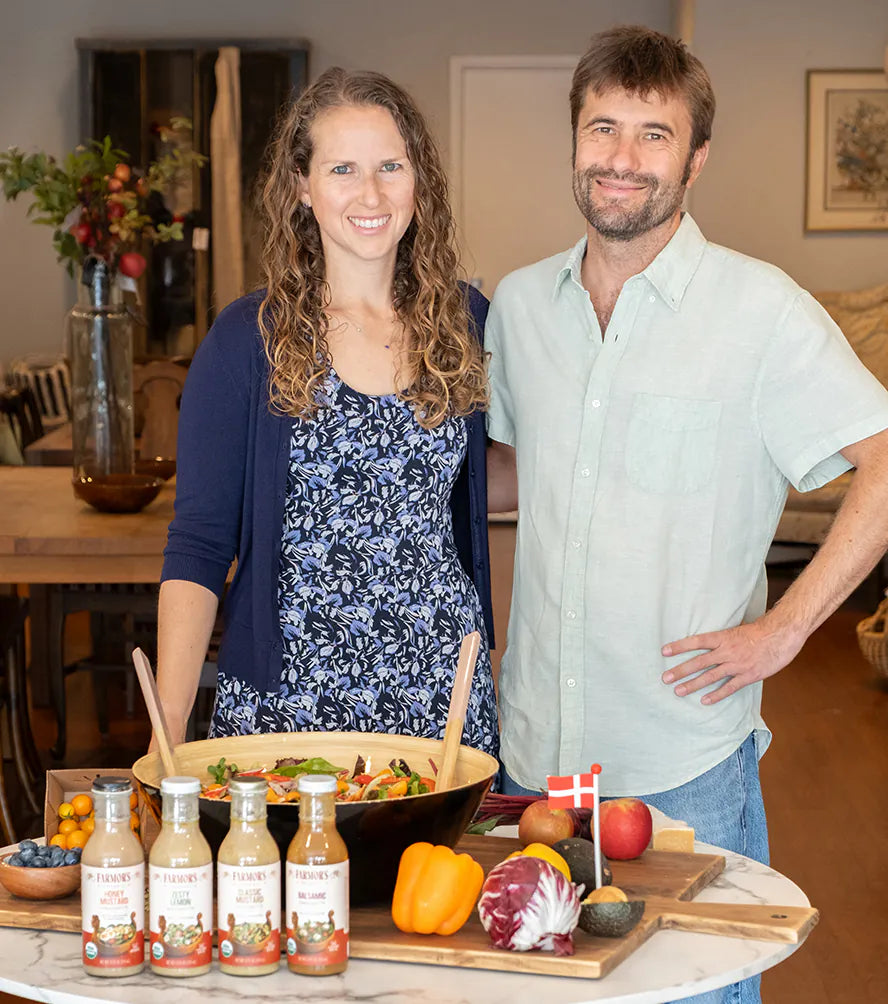 Alex and Adam behind a kitchen table with vegetables and Farmor’s bottles