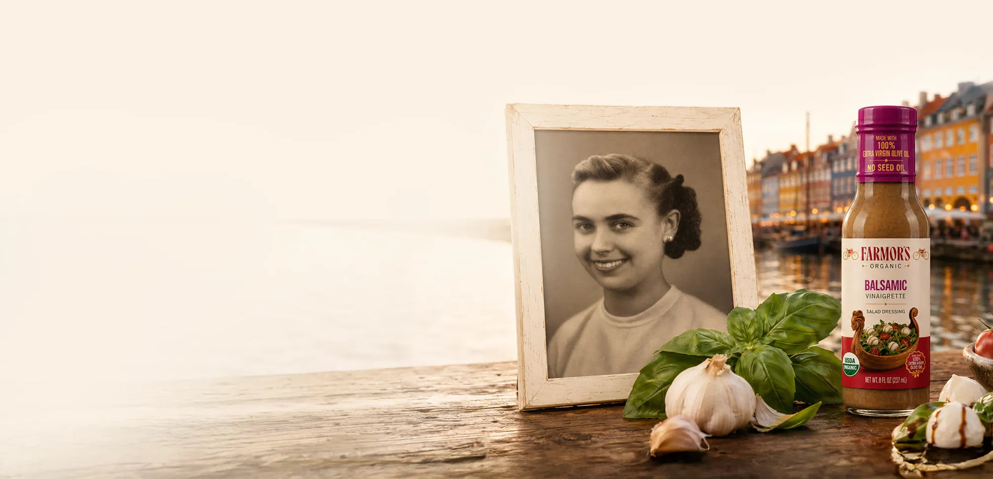 Copenhagen waterfront with a framed portrait of Alice, basil, garlic and a bottle of Farmor’s balsamic